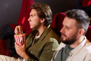 young man watching movie in cinema MFURVN9